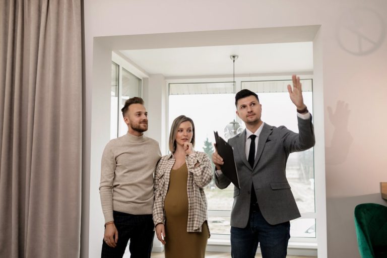 A professional real estate agent showing a modern apartment interior to international clients, illustrating the personalized service at Yes! Invest Guinea.